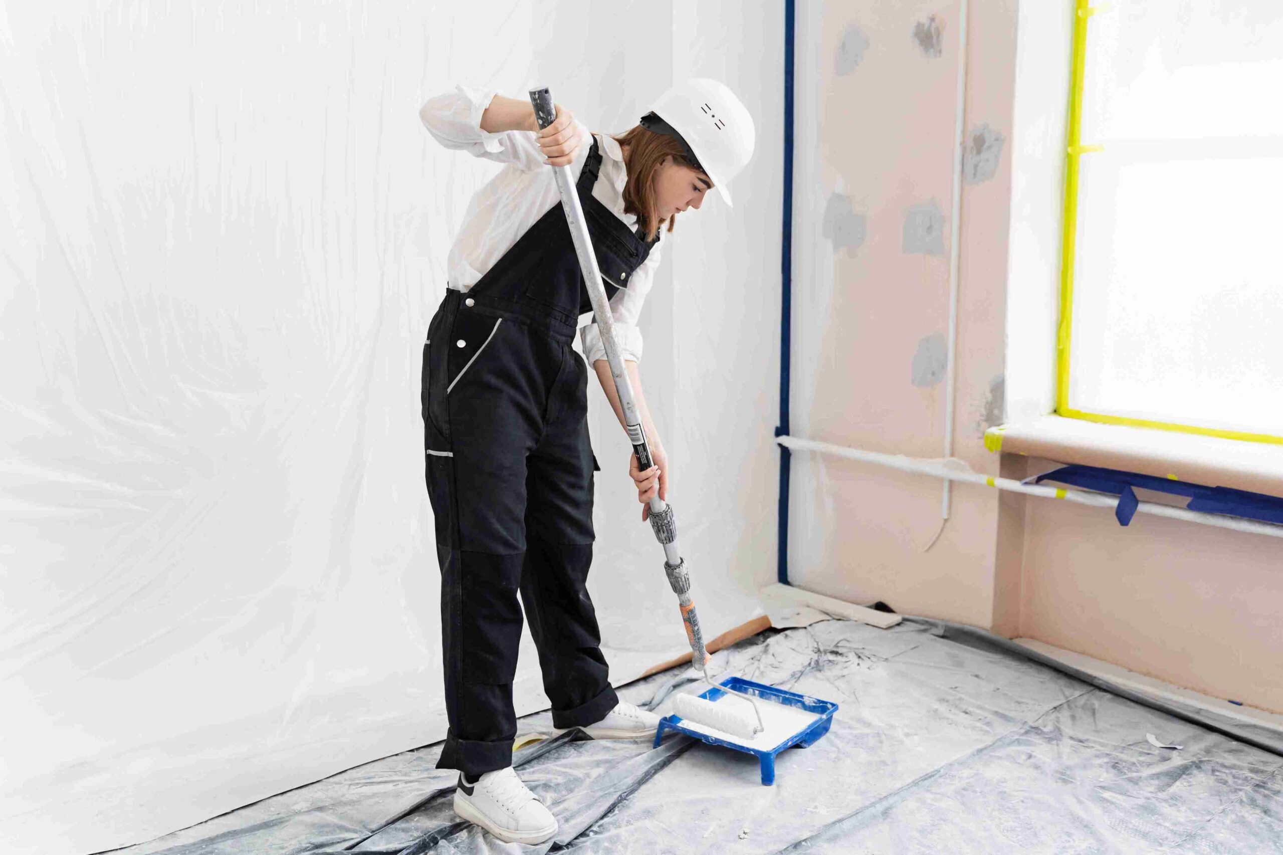 Woman painting house wall