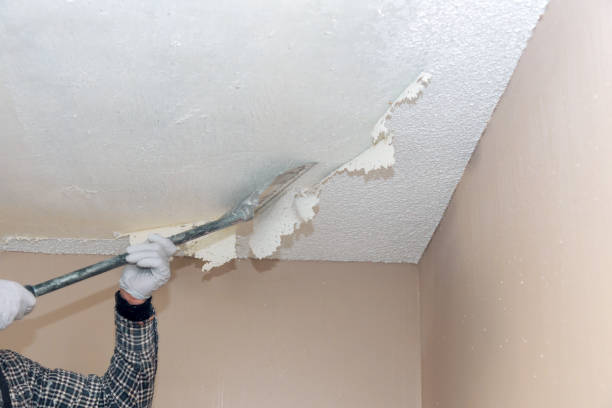 person removing popcorn ceiling