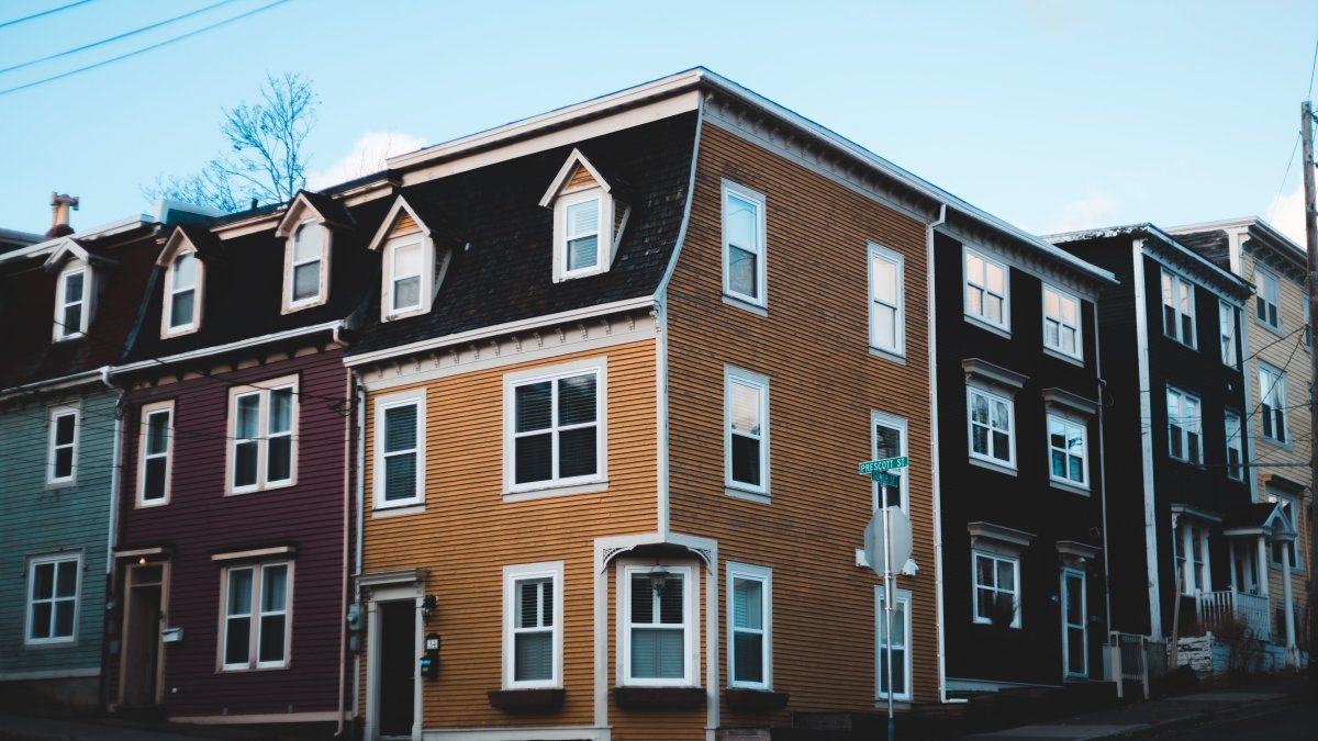Row houses with colorful facades showing potential wear