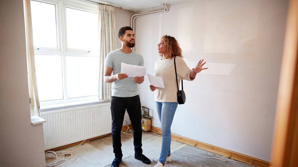Couple holding documents and discussing plans